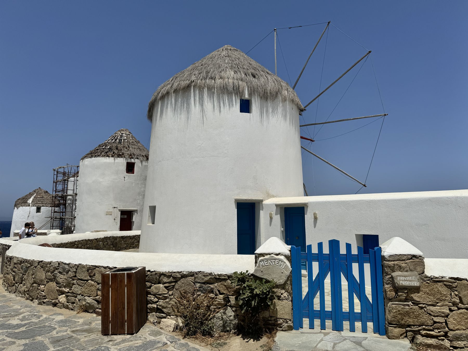 A whitewashed windmill on Mykonos with a blue gate